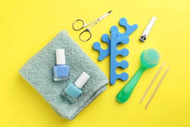 Photo of Set of pedicure tools on yellow background, flat lay