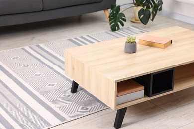 Photo of Coffee table with book and houseplant at home