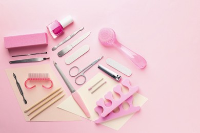 Photo of Set of pedicure tools on pink background, flat lay