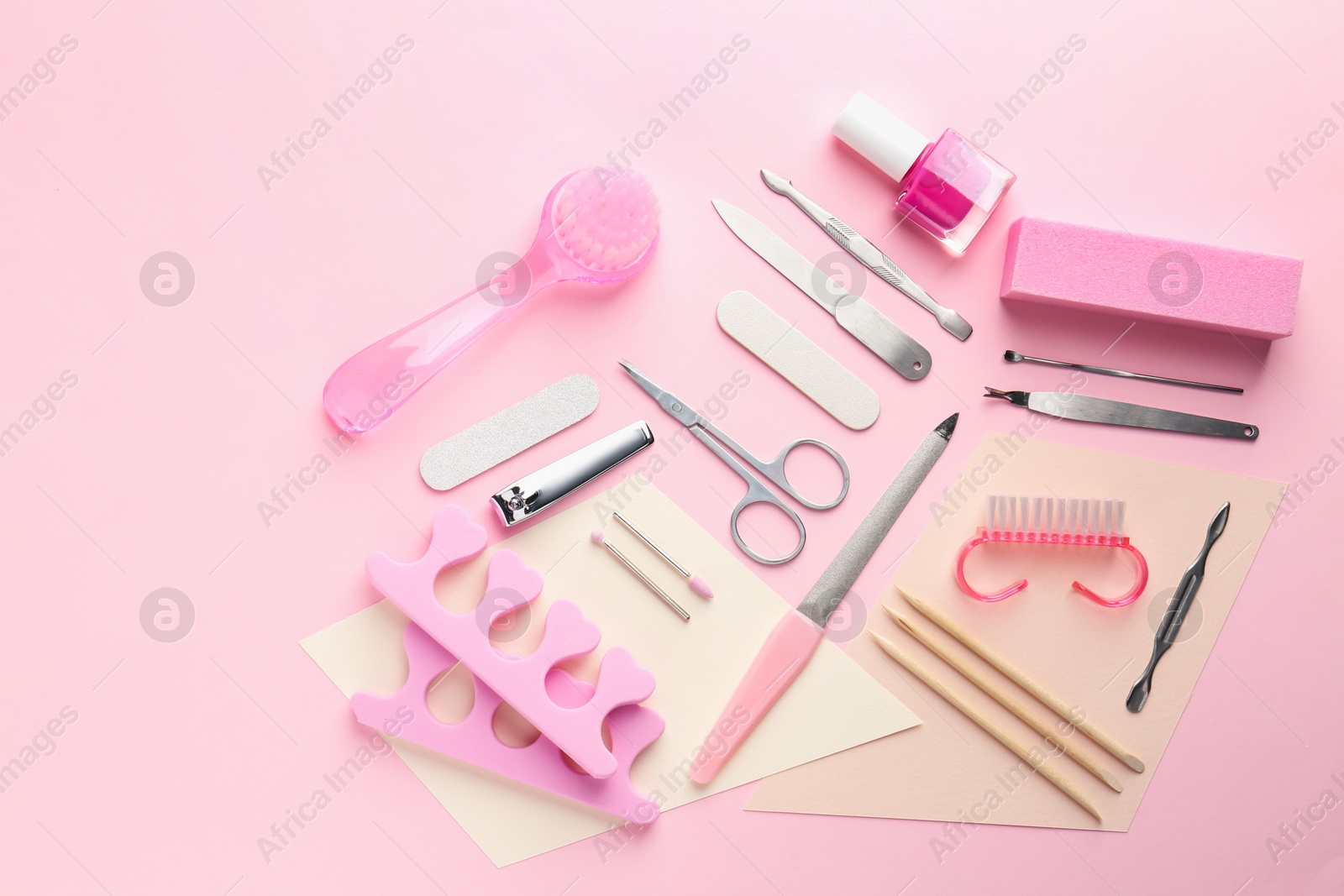 Photo of Set of pedicure tools on pink background, flat lay