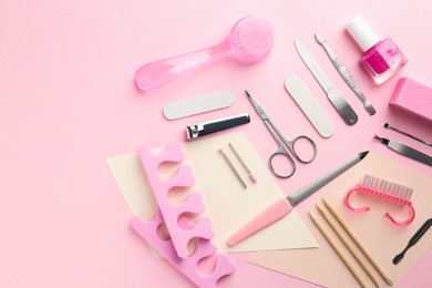 Photo of Set of pedicure tools on pink background, flat lay