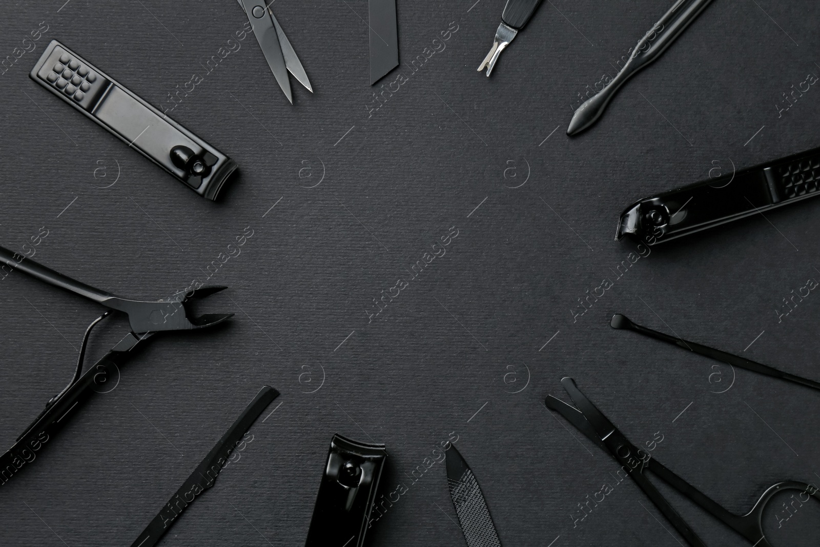 Photo of Set of pedicure tools on black background, flat lay. Space for text