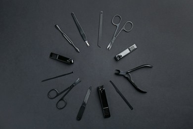 Photo of Set of pedicure tools on black background, flat lay