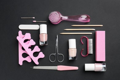 Photo of Set of pedicure tools on black background, flat lay