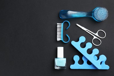 Photo of Set of pedicure tools on black background, flat lay. Space for text