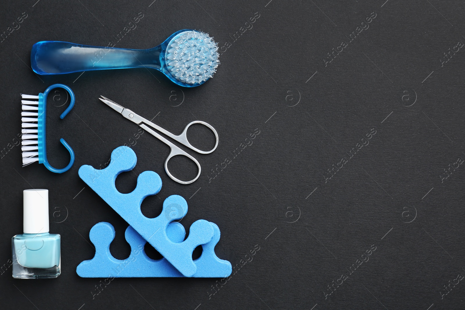 Photo of Set of pedicure tools on black background, flat lay. Space for text