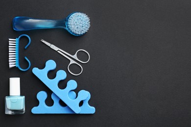 Photo of Set of pedicure tools on black background, flat lay. Space for text