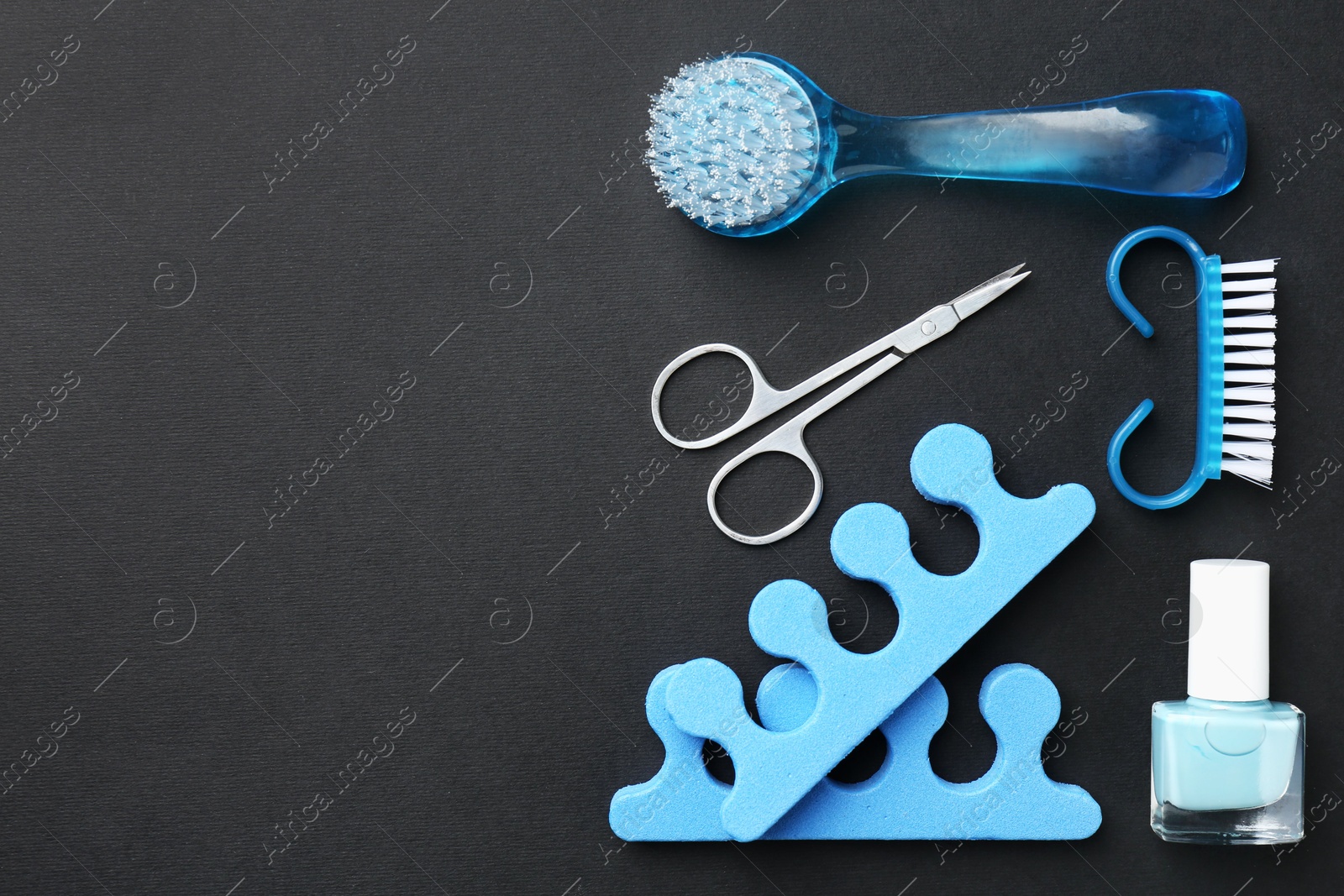 Photo of Set of pedicure tools on black background, flat lay. Space for text