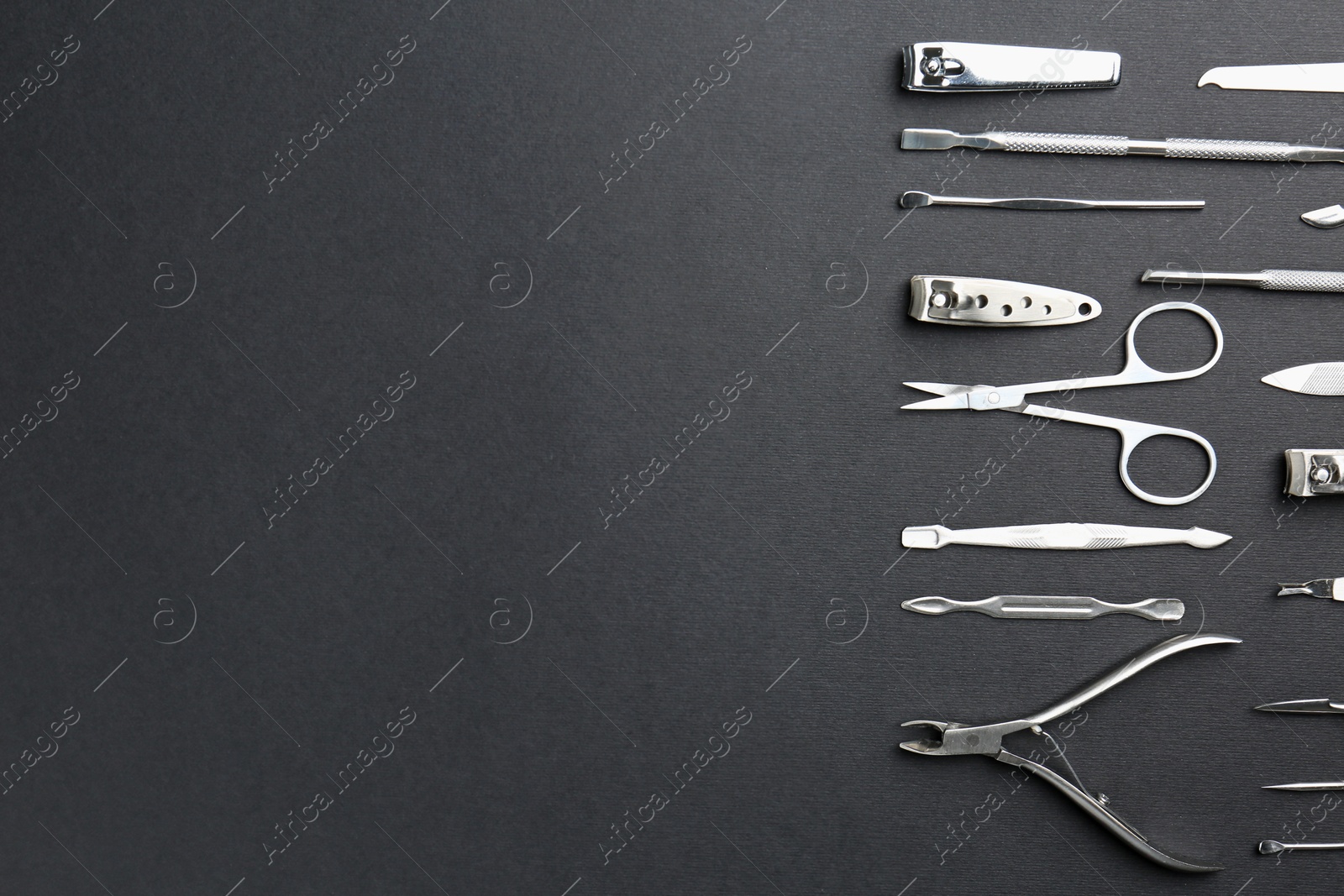 Photo of Set of pedicure tools on black background, flat lay. Space for text