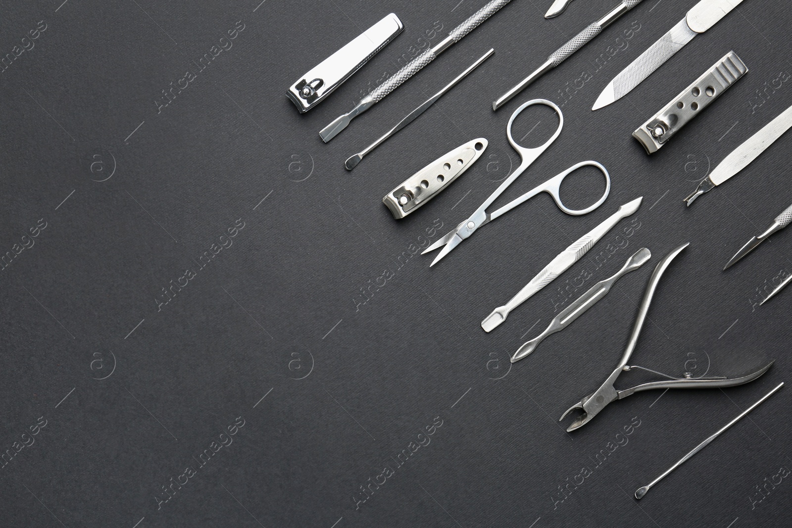 Photo of Set of pedicure tools on black background, flat lay. Space for text