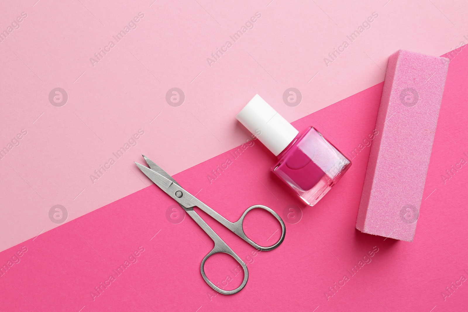 Photo of Pedicure procedure. Nail polish in bottle, buffer and scissors on pink background, flat lay. Space for text