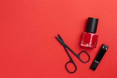 Photo of Set of pedicure tools on red background, flat lay. Space for text