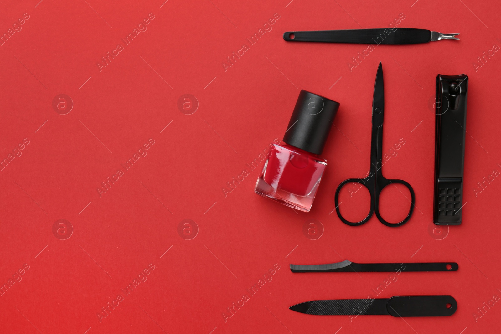 Photo of Set of pedicure tools on red background, flat lay. Space for text