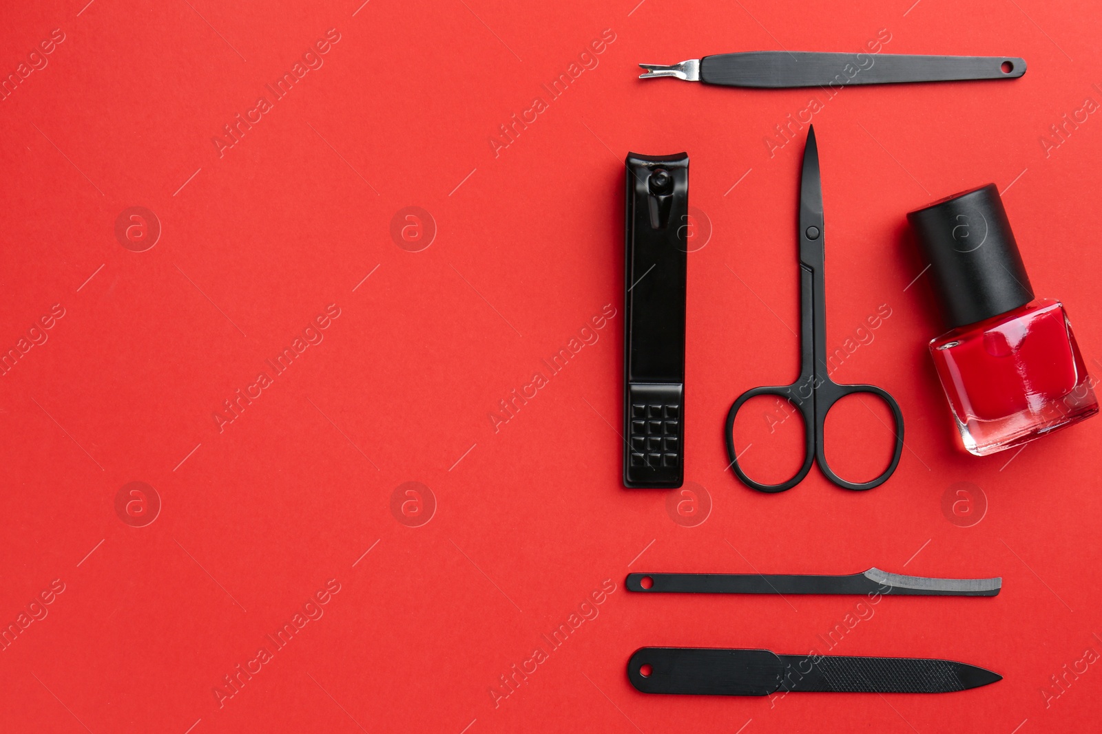 Photo of Set of pedicure tools on red background, flat lay. Space for text