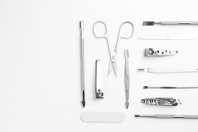 Photo of Set of pedicure tools on light background, flat lay. Space for text