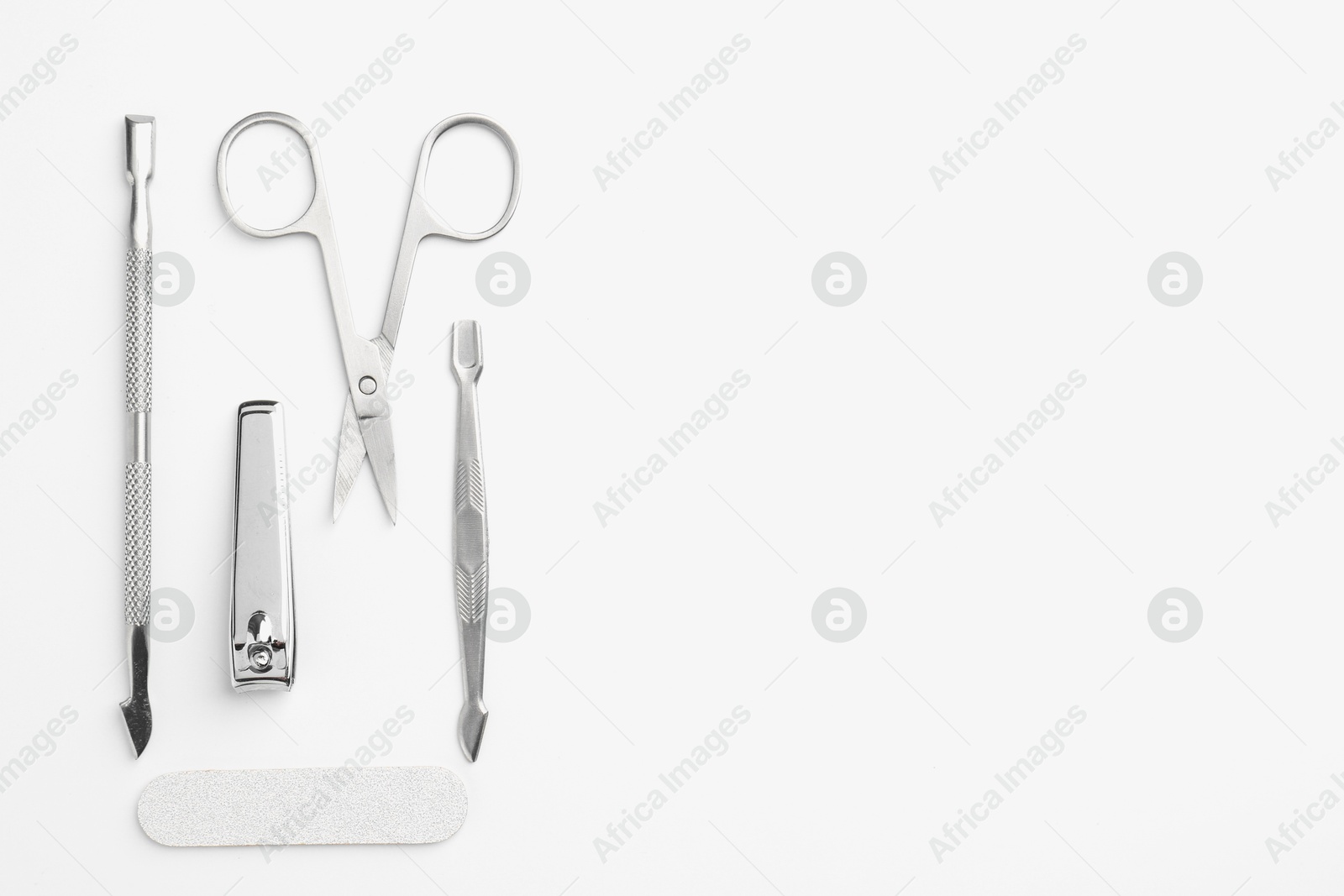 Photo of Set of pedicure tools on light background, flat lay. Space for text