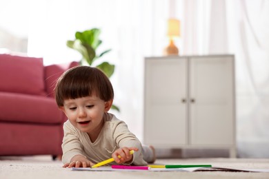 Photo of Cute little boy drawing on floor at home, space for text