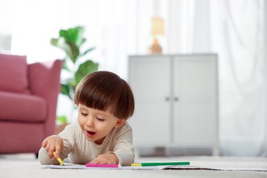 Photo of Cute little boy drawing on floor at home, space for text