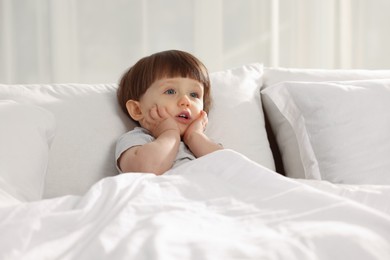 Photo of Cute little boy in bed at home