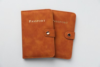 Photo of Passports in leather covers on grey background, top view