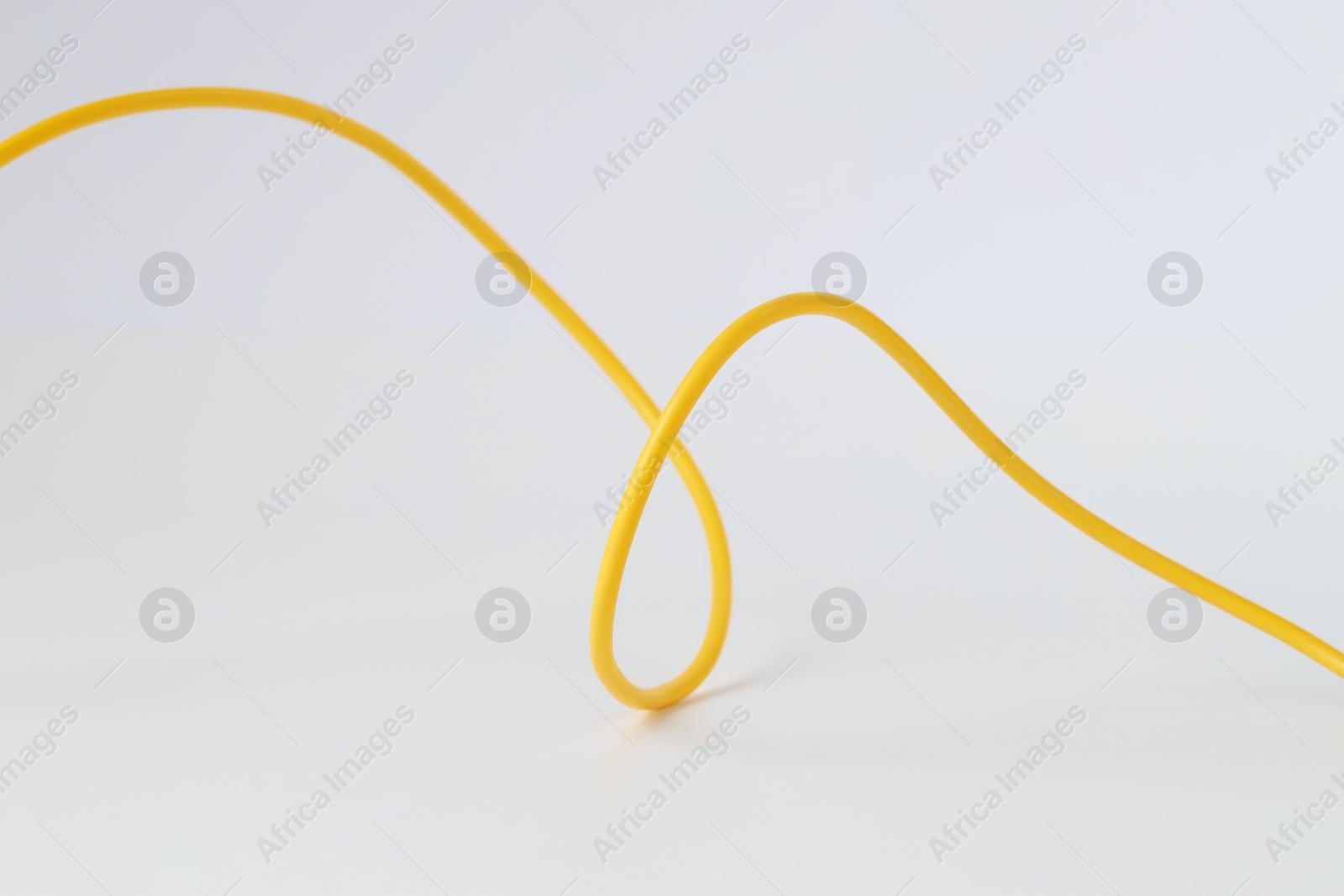 Photo of One yellow electrical wire isolated on white