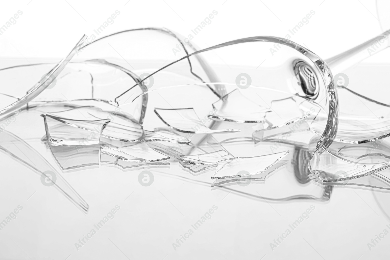 Photo of Pieces of broken wine glass on white background, closeup