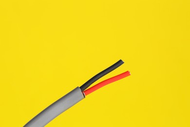 Photo of Grey stripped electrical wire on yellow background, closeup