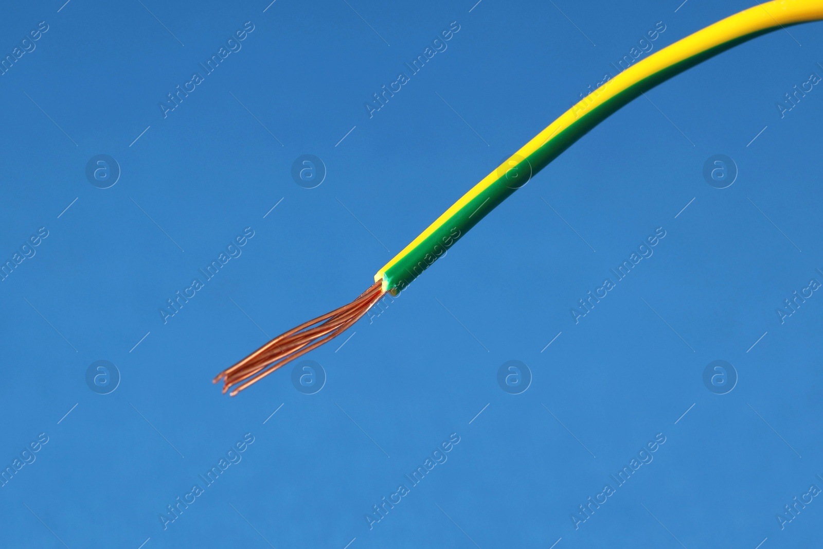 Photo of Stripped electrical wire on blue background, closeup