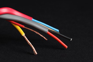 Photo of Many stripped electrical wires on black background, closeup