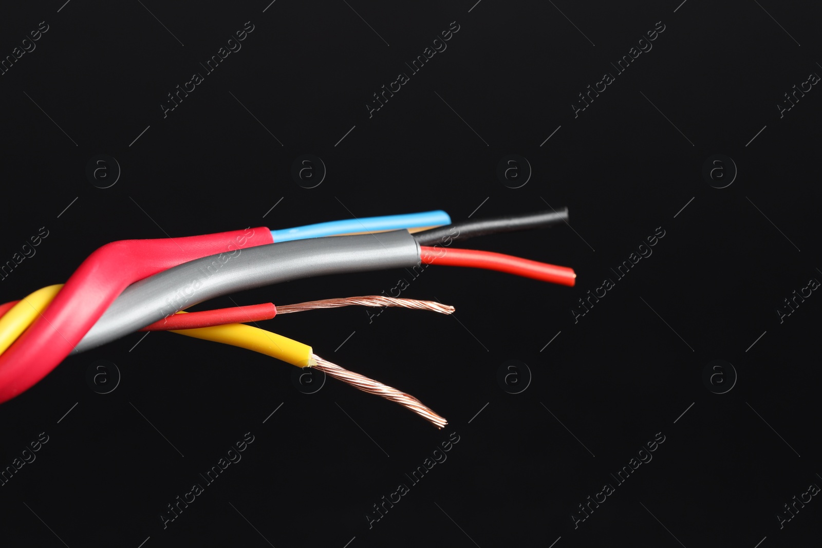 Photo of Many stripped electrical wires on black background, closeup