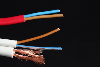 Photo of Stripped electrical wire on black background, closeup