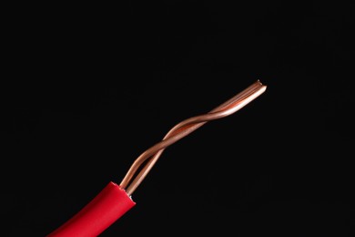 Photo of Red stripped electrical wire on black background, closeup