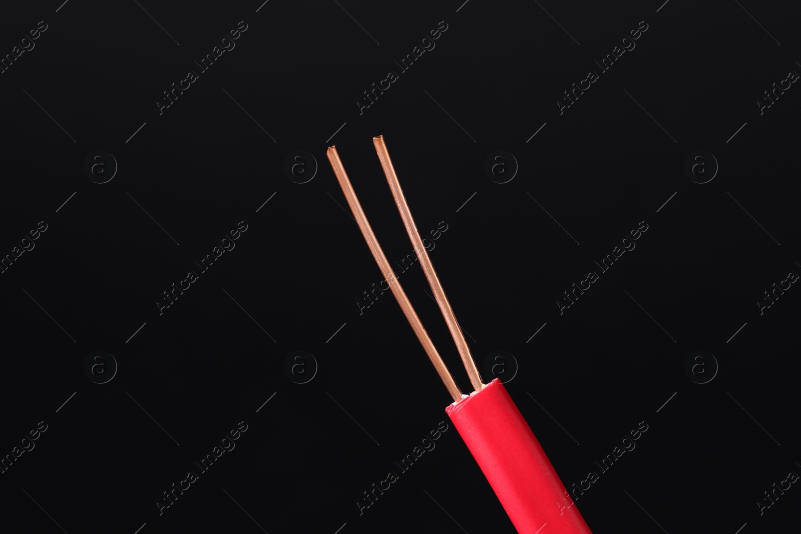 Photo of Red stripped electrical wire on black background, closeup