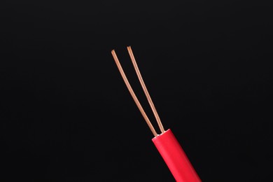 Photo of Red stripped electrical wire on black background, closeup