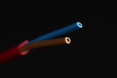 Photo of Red stripped electrical wire on black background, closeup