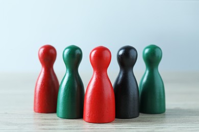 Photo of Human resources concept. Colorful figures on wooden table against light background, closeup