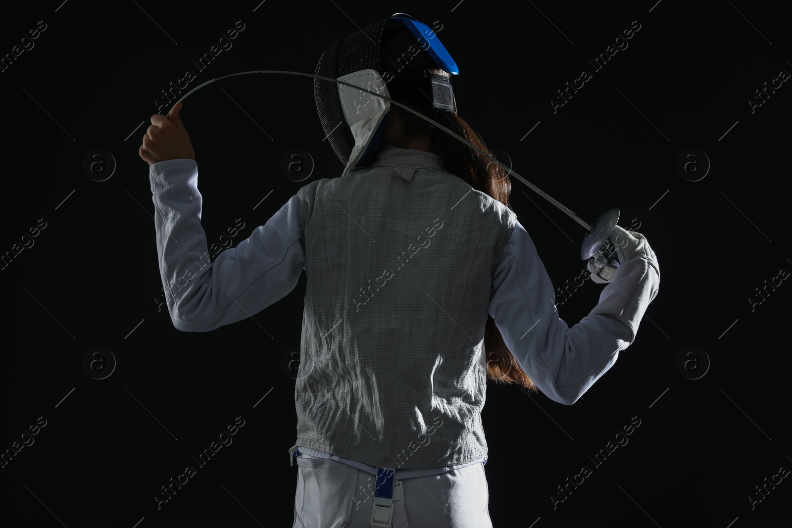 Photo of Fencer with epee on black background, back view