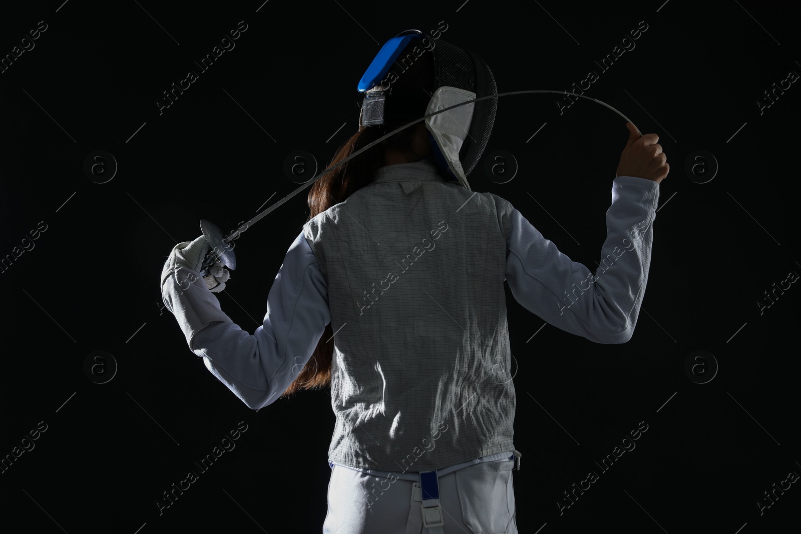 Photo of Fencer with epee on black background, back view