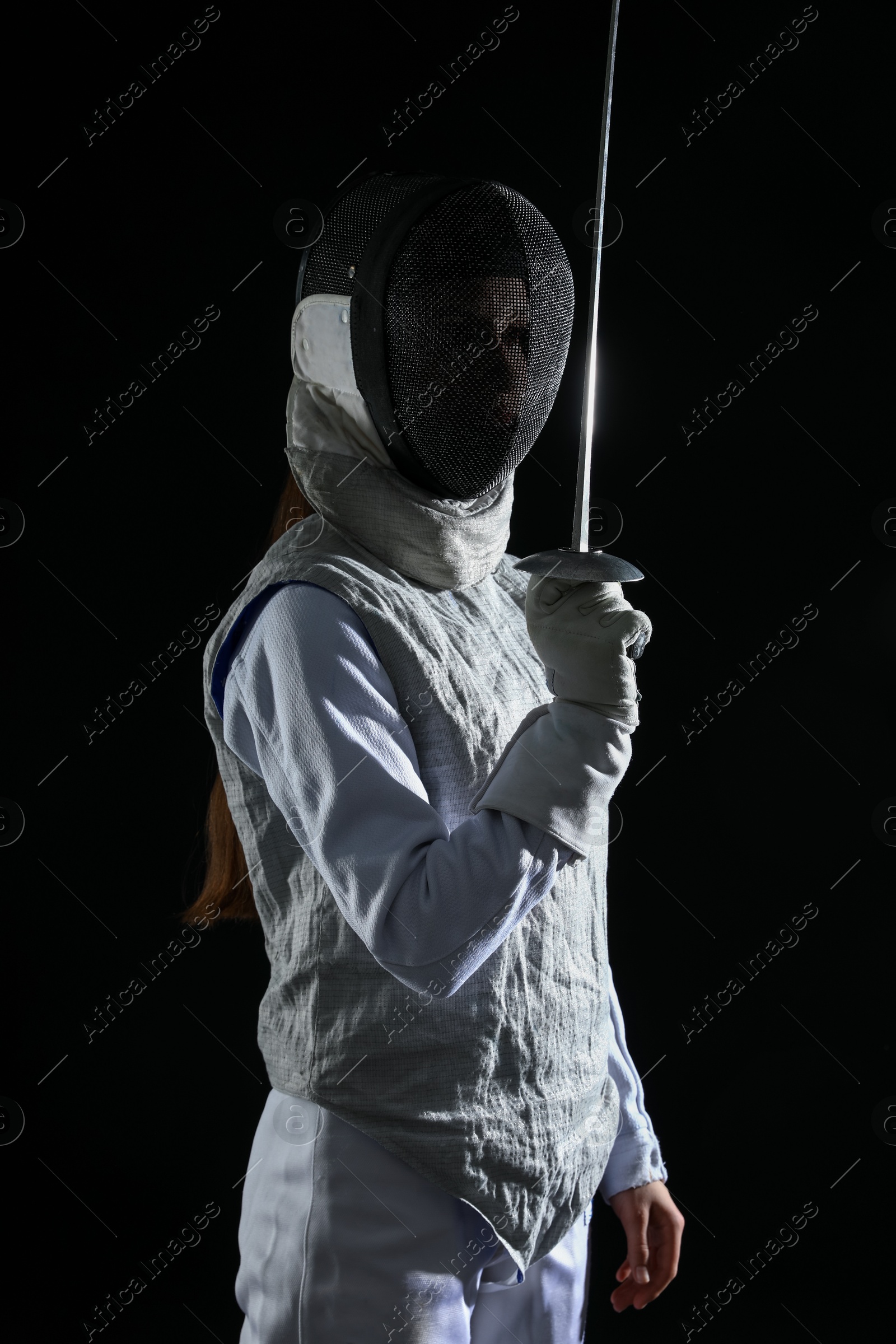 Photo of Fencer with epee on black background. Combat sport