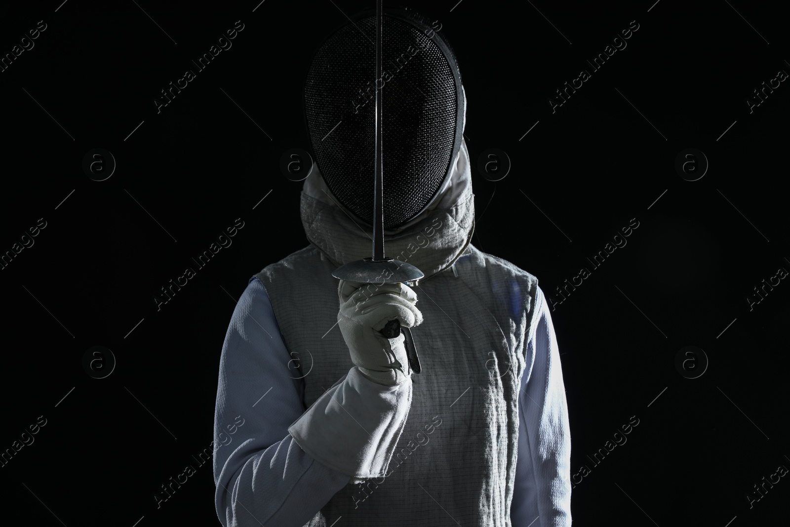 Photo of Fencer with epee on black background. Combat sport