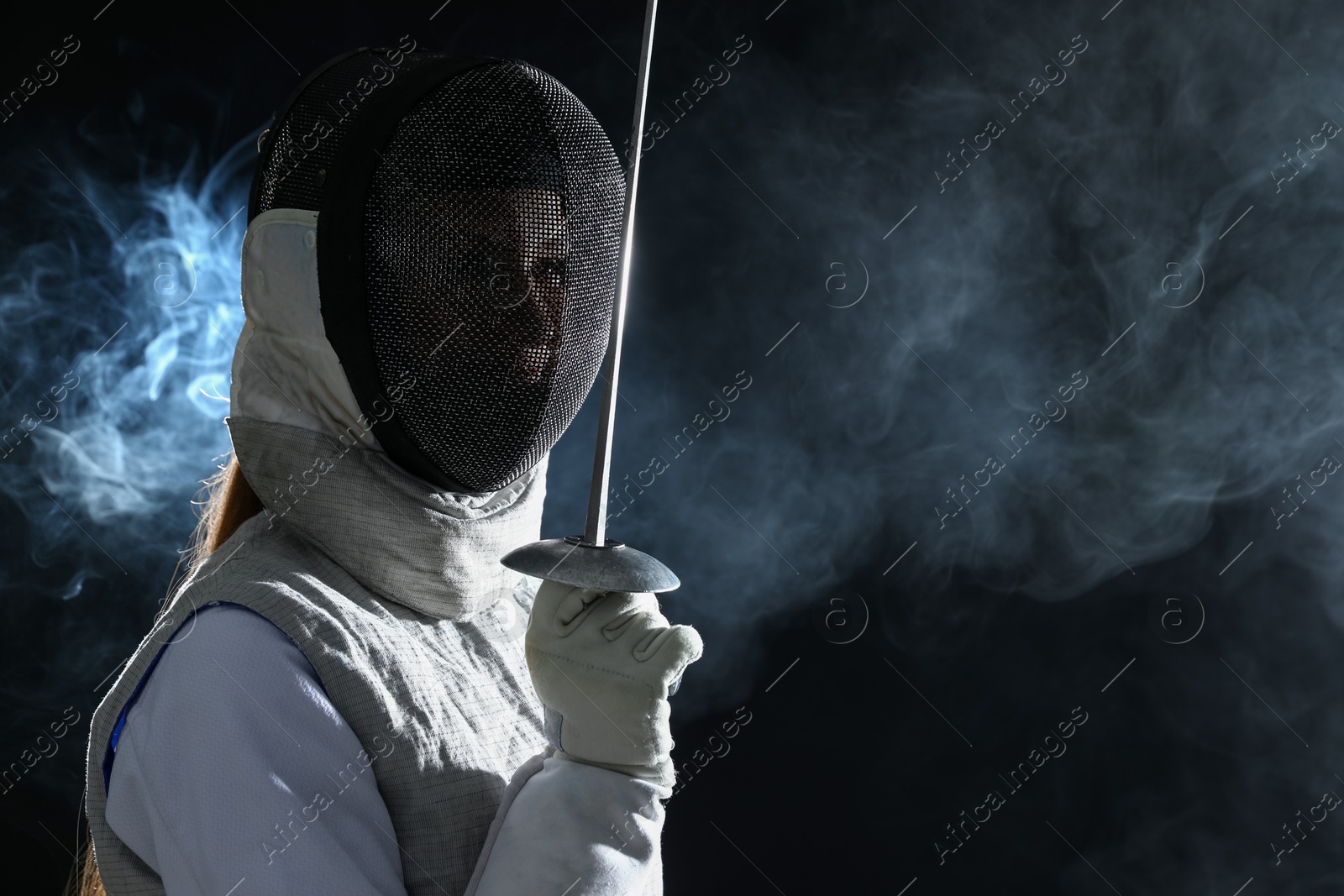 Photo of Fencer with epee in smoke on black background, space for text