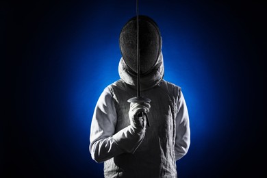 Photo of Fencer with epee on dark blue background