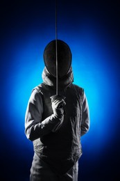 Photo of Fencer with epee on dark blue background