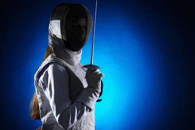 Photo of Fencer with epee on dark blue background, space for text