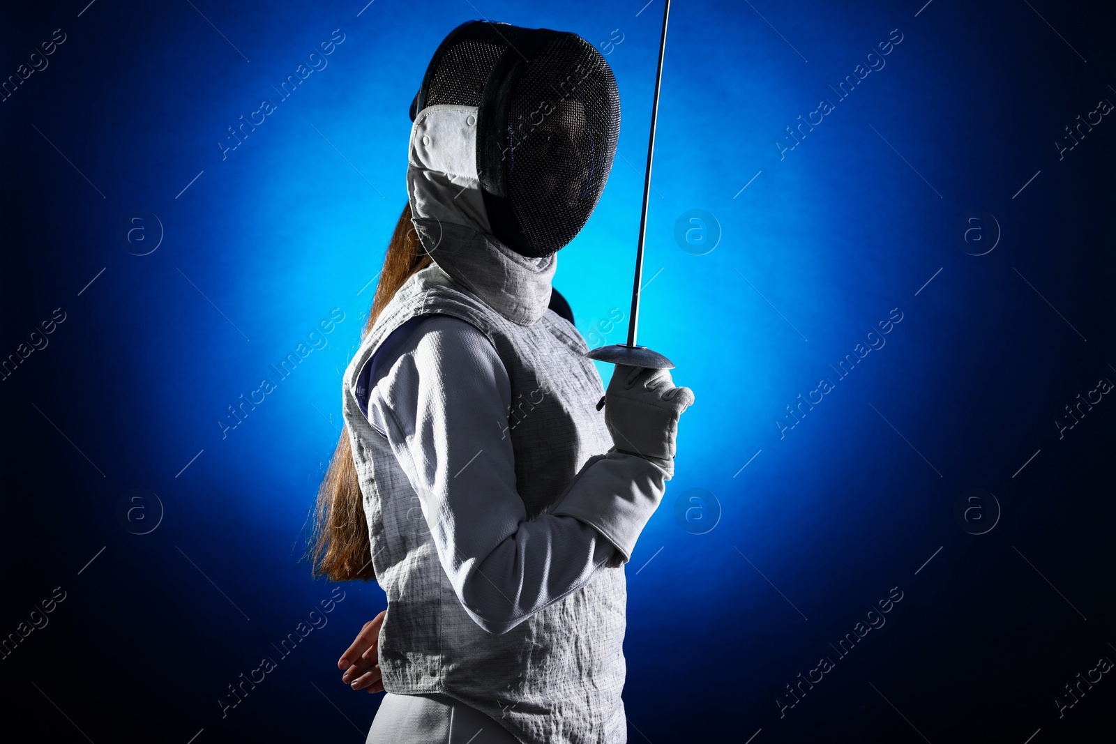 Photo of Fencer with epee on dark blue background