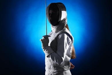 Photo of Fencer with epee on dark blue background