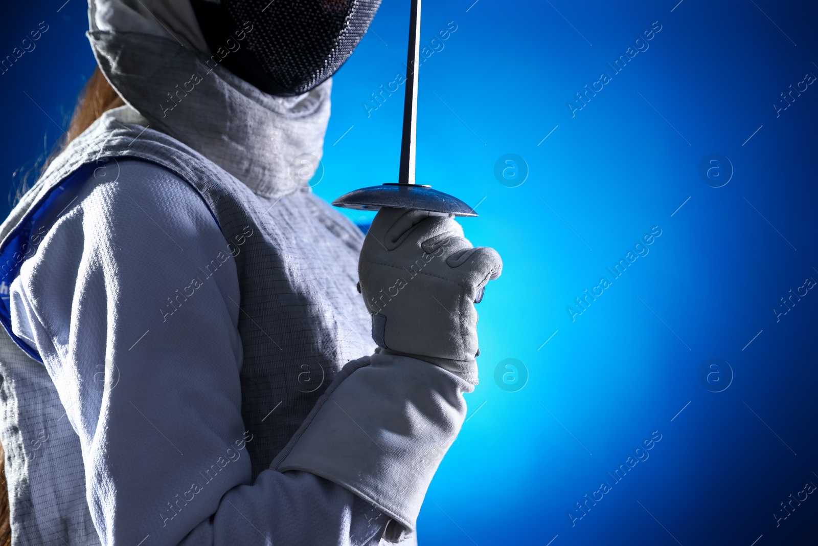 Photo of Fencer with epee on dark blue background, closeup. Space for text