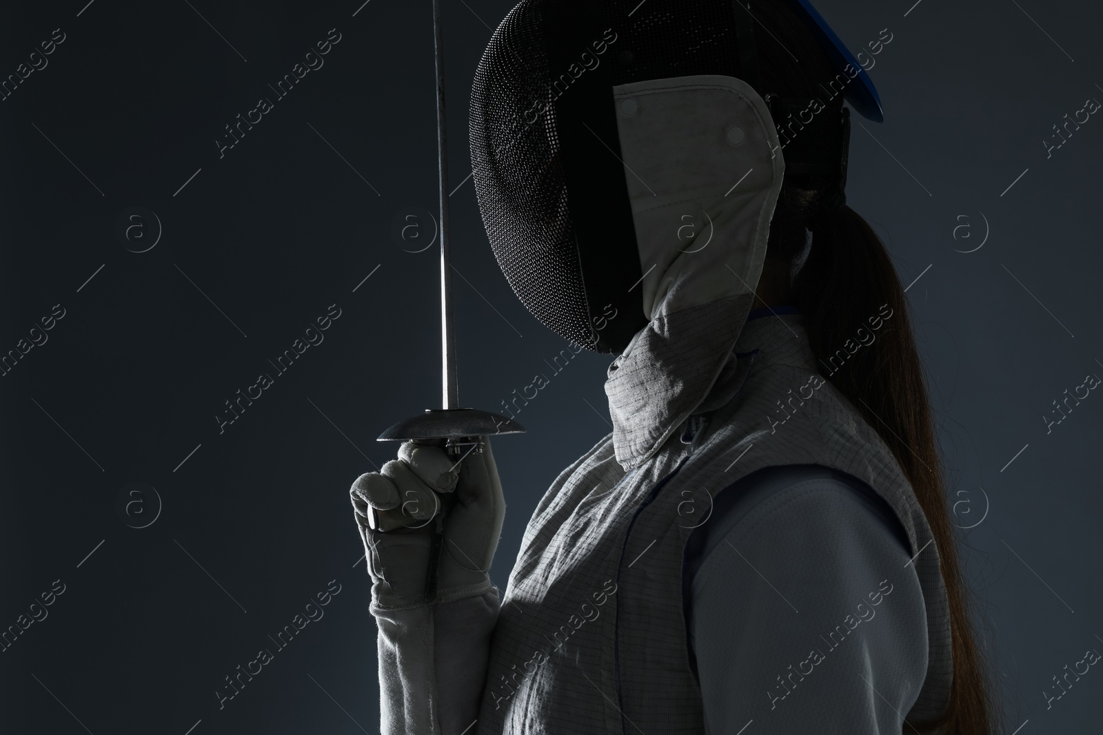 Photo of Fencer with epee on gray background. Combat sport