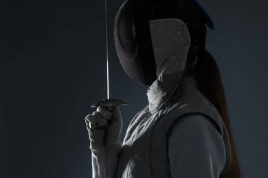 Photo of Fencer with epee on gray background. Combat sport