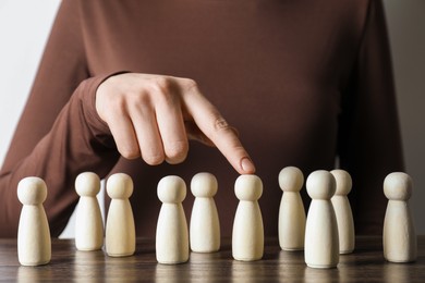 Photo of Human resources concept. Woman pointing at wooden piece among other ones at table, closeup